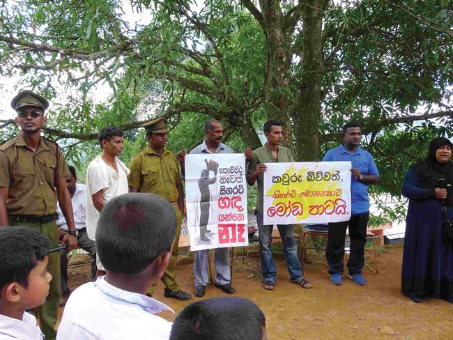 The street drama team holds up posters while making an outdoor presentation of the gospel to a group of uniformed schoolboys.
